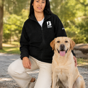 Brookline Lab Rescue embroidered Columbia fleece jacket worn outdoors with a yellow Labrador, featuring the embroidered Brookline Lab Rescue logo on the left chest.