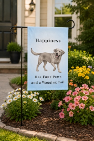 Light blue garden flag displayed on a black metal garden stand featuring a smiling Silver Labrador Retriever and the words "Happiness Has Four Paws and a Wagging Tail" in a colorful flower garden.