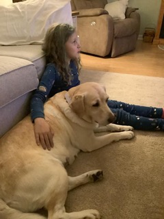 dog with a kid laying in front of the couch