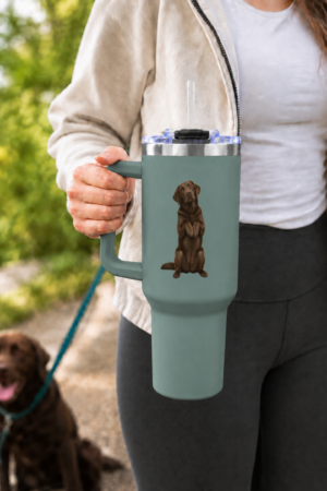 Begging for Treats Chocolate Labrador 40 oz Thermal Tumbler. Woman holding a sage-green 40 oz thermal tumbler with a matching handle and begging Chocolate Labrador design while walking a Chocolate Lab outdoors.